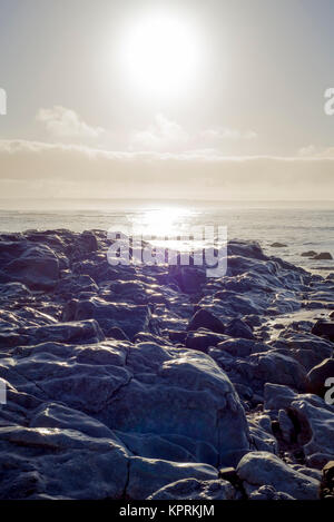 Onde di oltre bianche rocce al tramonto Foto Stock