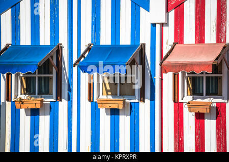 A strisce colorate case di pescatori in blu e rosso, Costa Nova, Aveiro, Portogallo Foto Stock