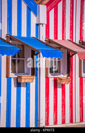 A strisce colorate case di pescatori in blu e rosso, Costa Nova, Aveiro, Portogallo Foto Stock