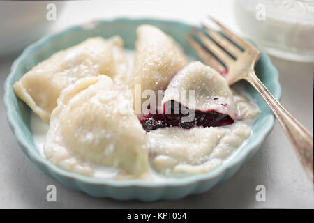 Gnocchi con mirtilli e crema. Pierogi dolci con frutti di bosco. Foto Stock