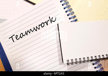 Il lavoro di squadra di scrivere su notebook Foto Stock