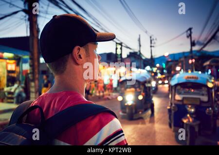 Giovane uomo che cammina sulla trafficata strada piena di negozi - Chiang Mai, Thailandia Foto Stock