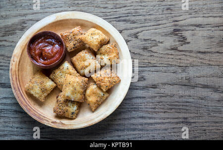 Piastra con ravioli fritti sulla tavola di legno Foto Stock