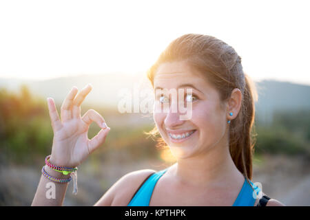 Felice e funny girl pareggiatore ponendo all'aperto al tramonto Foto Stock