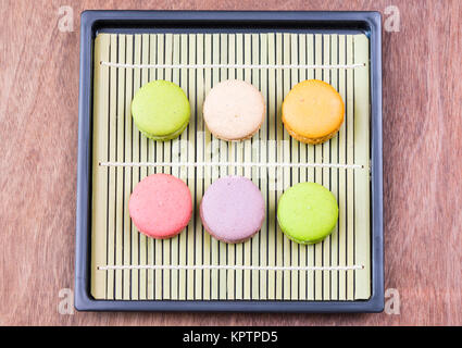 Macaron colorati su un tappetino di bambù Foto Stock