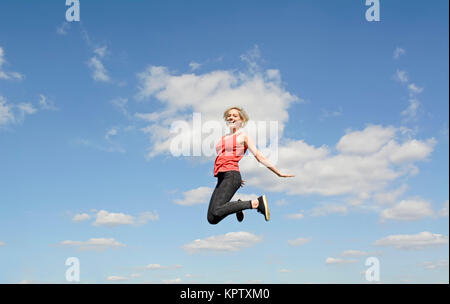 Frau macht Freudensprung Foto Stock