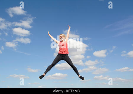 Frau macht Freudensprung Foto Stock