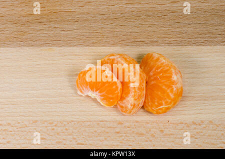 Tangerine segmenti su una tavola di legno Foto Stock