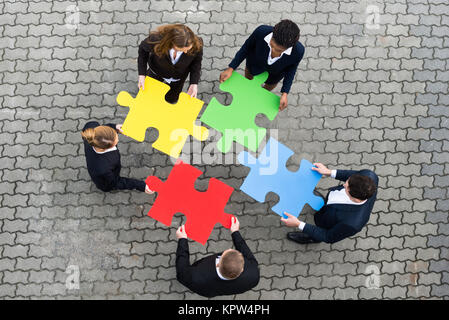 Businessman Holding colorato i pezzi del puzzle Foto Stock