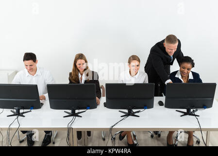 Imprenditore aiutando i suoi colleghi in ufficio Foto Stock