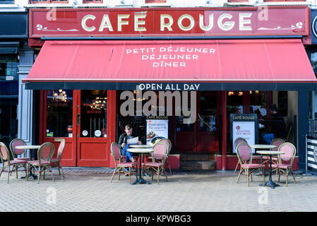 Uomo seduto leggendo un giornale presso la popolare Cafe Rouge esterno preso durante il giorno a Chelmsford Essex Inghilterra Foto Stock