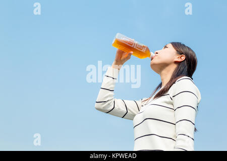 Giovane donna bere il tè da una bottiglia Foto Stock