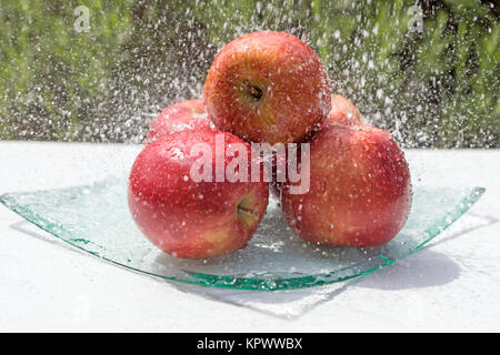 Le mele rosse sono nel flusso di acqua Foto Stock