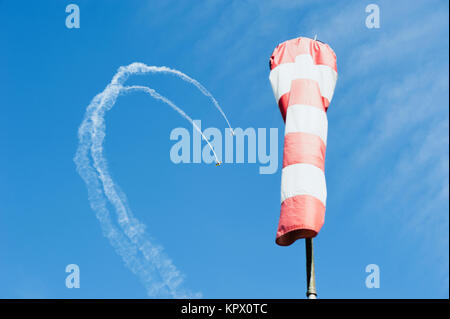 Due mono-motore aereo nel cielo disegnare un loop out di nuvole sullo sfondo della direzione del vento Foto Stock