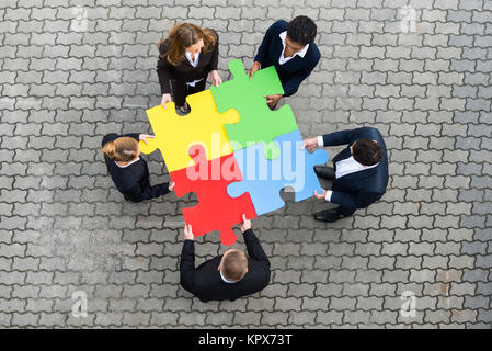 Businessman Holding colorato i pezzi del puzzle Foto Stock