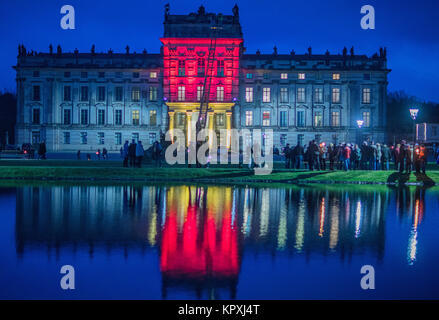 Ludwigslust, Germania. Xvi Dec, 2017. Xviii finestra del calendario di Avvento - visitatori in piedi davanti il colorfully castello illuminato durante l inaugurazione del Barocco Mercatino di Natale di Ludwigslust, Germania, 16 dicembre 2017. Durante il terzo fine settimana di avvento corte signore e signori. La passeggiata attraverso il castello e l'adiacente piccolo mercato con offerte tipiche della regione. Il castello è di Natale organizzato dal castello di Ludwigslust club di tifosi. Credito: Jens Büttner/dpa-Zentralbild/dpa/Alamy Live News Foto Stock