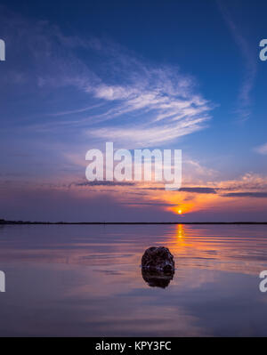 La pietra in acqua al tramonto Foto Stock