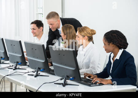 Imprenditore aiutando i suoi colleghi in ufficio Foto Stock