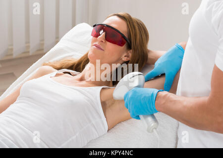 La donna riceve le ascelle Depilazione laser Foto Stock