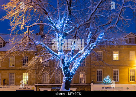 Blu luci di Natale in una struttura ad albero con neve a notte a Chipping Norton, Cotswolds, Oxfordshire, Inghilterra Foto Stock