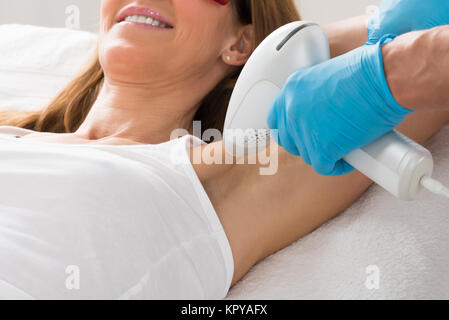 La donna riceve le ascelle Depilazione laser Foto Stock