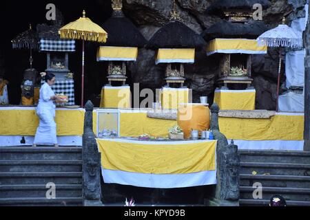 Donna Balinese nelle vicinanze altari giallo all'interno di Goa Lawah tempio indù di Bali, Indonesia Foto Stock