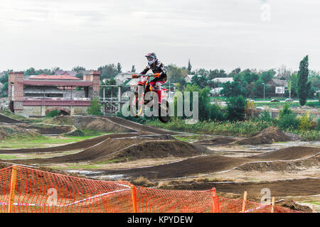 Il titolo di corse per un motociclo partecipa a una gara di motocross, salta su un trampolino di lancio. Close-up. Foto Stock