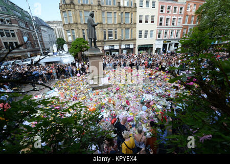 Revisione dell'anno 2017: Maggio: folle guardare il omaggi floreali dopo un minuto di silenzio in St Ann's Square, Manchester, per ricordare le vittime del terrore attentato al Manchester Arena durante un Ariana Grande gig in precedenza che settimana. Foto Stock