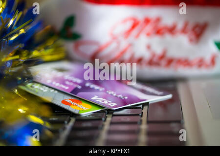 Concetto di immagine della spesa a Natale con le carte di credito/debito sulla tastiera di un computer. Foto Stock