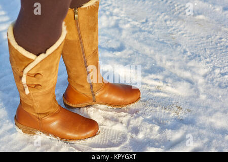 Gamba donna inverno marrone stivali di pelliccia di camminare sulla neve in  un parco d'inverno. Primo piano della suola di avvio a caldo Foto stock -  Alamy
