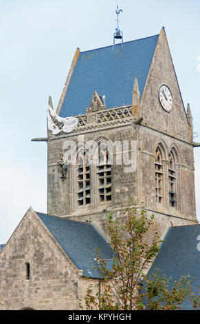 Un manichino paracadutista noi è tenuto appeso sulla torre della chiesa a Sainte-Mere-Eglise per commemorare un vero incidente sulla mattina del D-Day 6 giugno 1944 Foto Stock