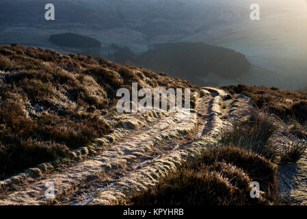 Frosty sentiero nelle colline sopra Hayfield nel Peak District. Bright sole mattutino. Foto Stock