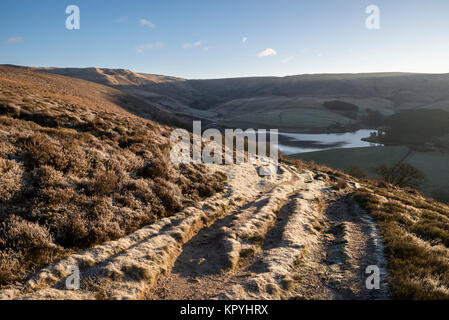 Frosty sentiero nelle colline sopra Hayfield nel Peak District. Bright sole mattutino. Foto Stock