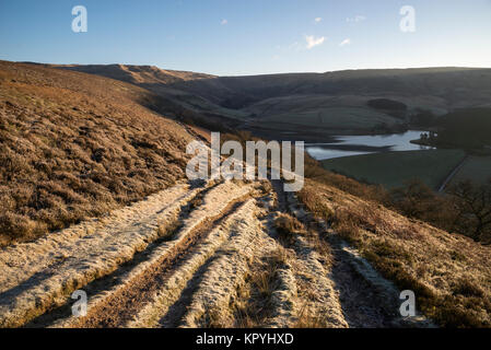 Frosty sentiero nelle colline sopra Hayfield nel Peak District. Bright sole mattutino. Foto Stock