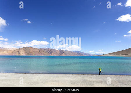 Giovane ragazzo caucasico in esecuzione sulla spiaggia di sabbia bianca a Salt Lake Pangong Tso, Ladakh, Jammu e Kashmir in India. Foto Stock