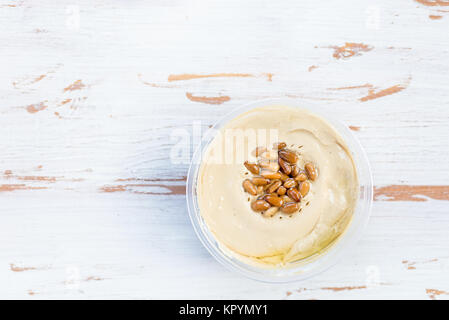 Classic Hummus realizzato da ceci con pinoli sulla parte superiore di legno sfondo rustico, vista dall'alto Foto Stock