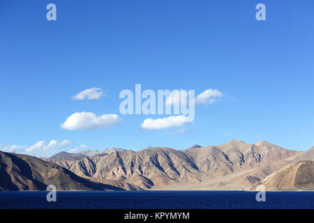 Paesaggio arido e le montagne himalayane dall'azzurro del lago di Pangong Tso, Ladakh, Jammu e Kashmir in India. Foto Stock