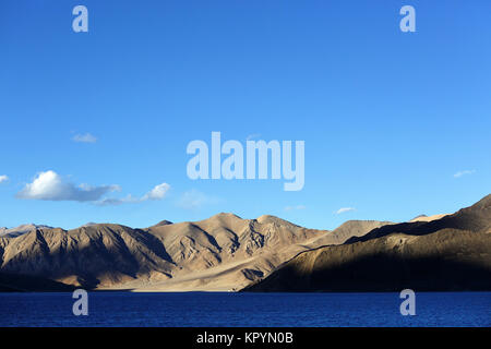 Paesaggio arido e le montagne himalayane dall'azzurro del lago di Pangong Tso, Ladakh, Jammu e Kashmir in India. Foto Stock