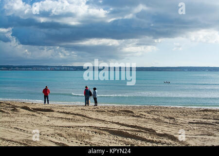 PLAYA DE PALMA DI MALLORCA, Spagna - 16 dicembre 2017: Donna uomo e cane sulla spiaggia invernale in una giornata ventosa sul dicembre 16, 2017 a Maiorca, Baleari islan Foto Stock