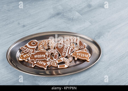 Anno nuovo forme per buona fortuna da Natale gingerbread. Piastra di argento decorato con piggies, cavalcate e Jingle Bells. Foto Stock