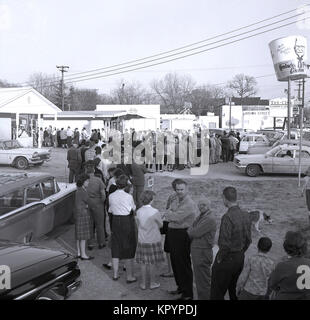 Anni sessanta, ora che una lunga coda...foto storiche da questa epoca che mostra un americano di uomini e di donne in coda al di fuori di un Kentucky Fried Chicken fast food uscita nella speranza di vincere uno dei premi in denaro in offerta all'interno del negozio, STATI UNITI D'AMERICA. Foto Stock