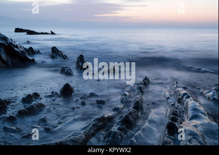 Sunrise oltre la costa rocciosa a Hannafore in Oriente Cornovaglia Foto Stock