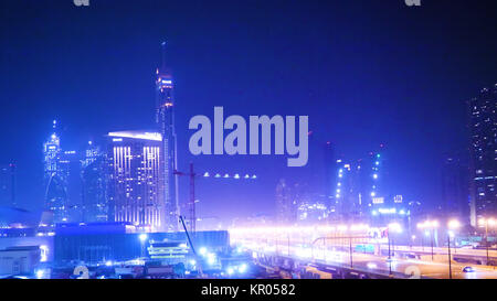 Grande città traffico. autostrada e il traffico nella città di notte. Skyline della città con più cavalcavia sopra la luna piena. Traffico sentieri di luce. Foto Stock