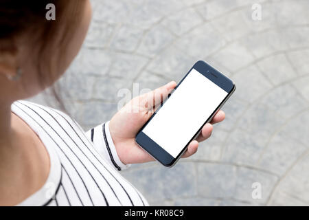 Donna che guarda al telefono su strada in città Foto Stock