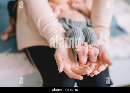 Baby il piede nella mani di Madre Foto Stock