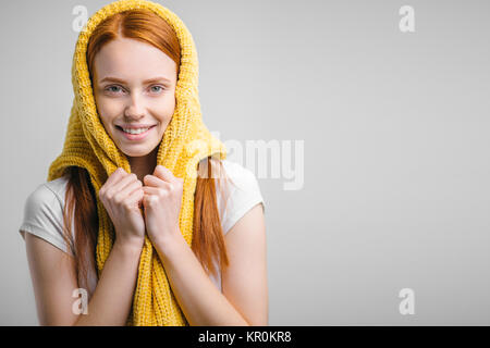 Redhead girl maglia indossa un maglione sulla testa come velo Foto Stock