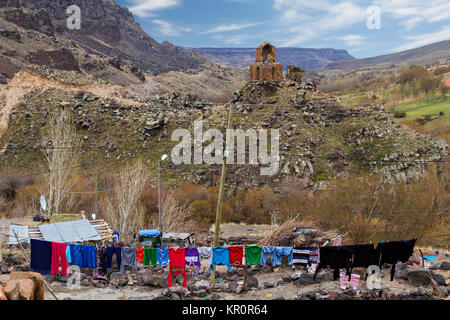 Biancheria colorata in Kilittas Village di Kars, Turchia, sul bagno turco frontiera armena. Il servizio lavanderia è in Turchia, antica chiesa è in Armenia. Foto Stock