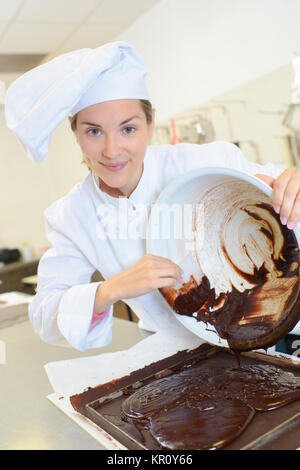 Lo Chef raschiatura miscela di cioccolato in teglia da forno Foto Stock