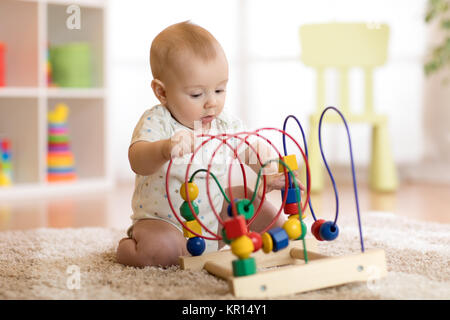 Il bambino gioca con il giocattolo educativo in vivaio Foto Stock