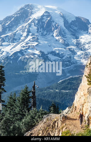 Donna escursioni lungo un sentiero alpino, Mt Rainier, Washington, Stati Uniti Foto Stock